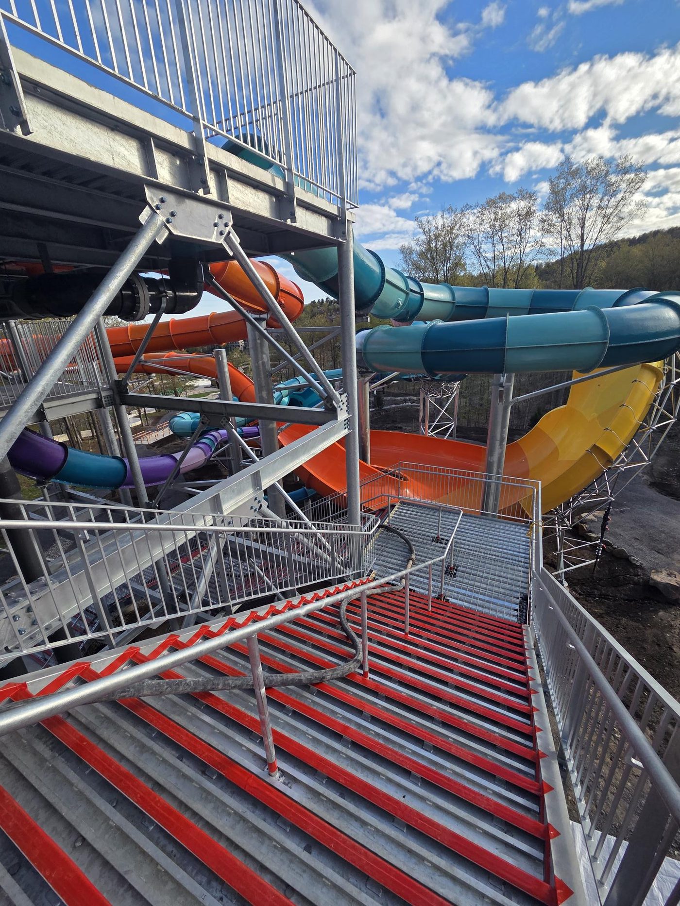 Glissades d'eau colorées du parc aquatique de Bromont - tubes bleus, oranges, jaunes et violets avec escaliers métalliques construits par Norvik Construction
